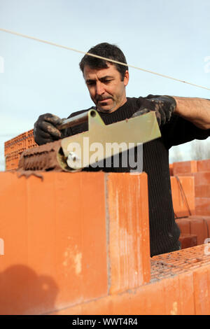 Mason using special device to pour cement evenly Stock Photo