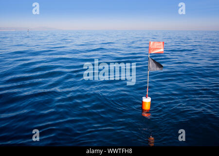 Longliner and trammel net buoy with flag pole in blue sea Stock Photo