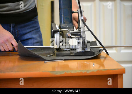 Worker man cutting a metal pipe in two pieces and lot of sparks flying straight into the camera close-up. Stock Photo