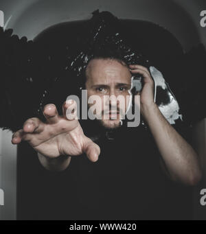 Mystery, Fallen angel, man in a bathtub with black water and wings, submerged, depression, loss Stock Photo