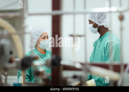 Laboratory technicians at work in medical plant with machinery and computers Stock Photo