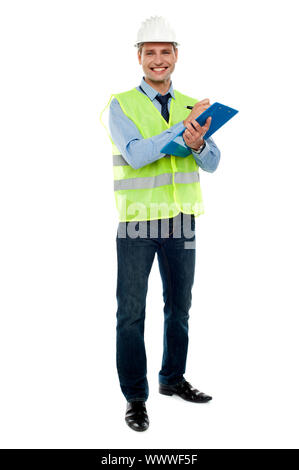 Full length portrait of handsome architect writing key notes on clipboard Stock Photo