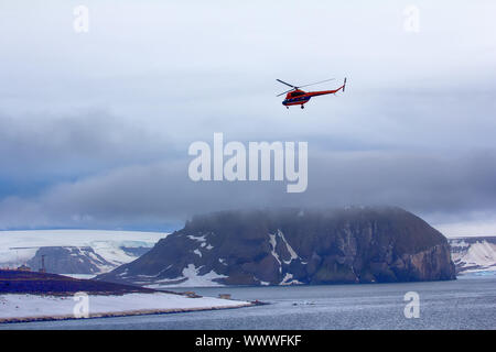 Helicopter brings scientists and extreme tourists on harsh polar Islands Stock Photo