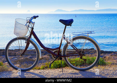 Bicycle in formentera beach on Balearic islands with Ibiza sunset background Stock Photo