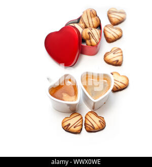 heart shaped cream cookies on red heart metal box and couple of espresso coffee cups Stock Photo
