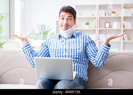 The man freelancer in a cervical collar neck brace working from home Stock Photo