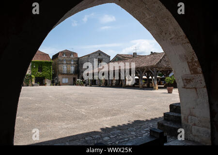 The main square of Monpazier, viewed through an archway Stock Photo