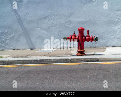 Two sided red roadside fire hydrant on a pavement in Hamilton Bermuda Stock Photo