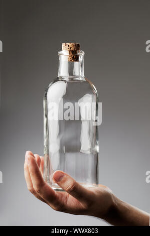 Man holding an old-fashioned glass bottle in his hand. Stock Photo
