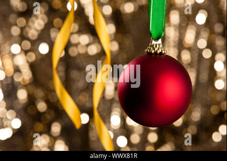 Single Christmas bauble in front of a gold glitter background Stock Photo