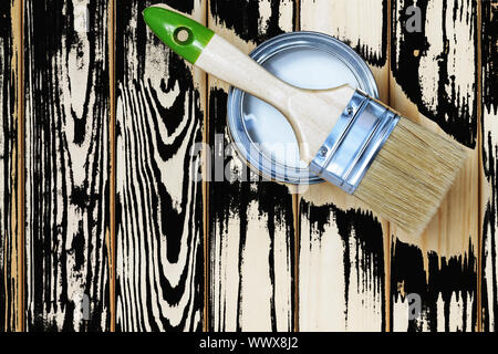 Brush and paint jar with white on a wooden background. Stock Photo