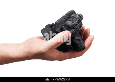 Man holding lumps of charcoal in his hand Stock Photo