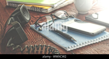 workplace. notebooks with pens and glasses lie on a wooden table. modern office Stock Photo