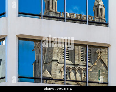 Cathedral of the Most Holy Trinity Bermuda, seen distorted and reflected in an office block's windows Stock Photo