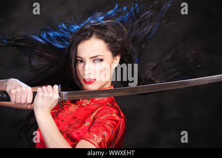 Pretty kimono woman in action with katana/sword Stock Photo