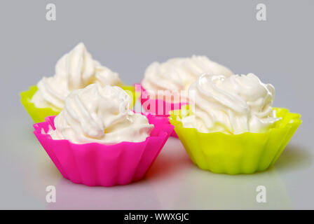 Four portions of whipped cream over white background. Stock Photo
