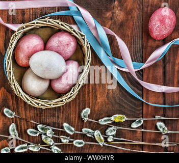 Easter. Multi-colored Easter eggs in a basket, willow, colored tape. top veiw. Stock Photo