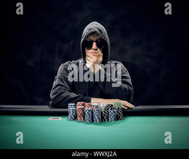 Portrait of a professional poker player sitting at a poker table Stock Photo