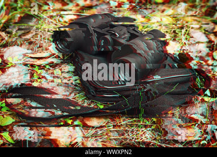 The binoculars and case binoculars on the background of autumn leaves. Glitch effect Stock Photo