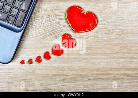 Red hearts on the office desk are connected to the computer. Concept: Valentine's Day, message, corr Stock Photo