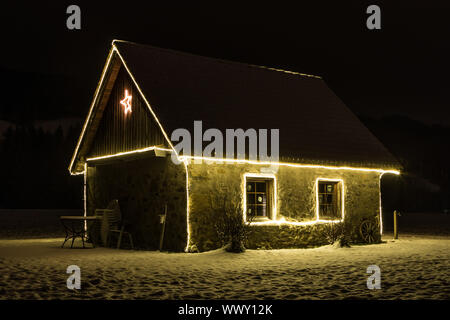 Small cottage with fairy lights at night and snow, Malters, Lucerne, Switzerland, seasons Stock Photo