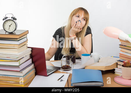 Student yawns after drinking 3 cups of coffee, doing graduation project at night Stock Photo