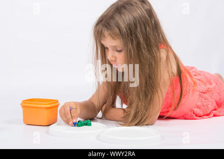 Five-year girl collects mosaic lying on the floor Stock Photo