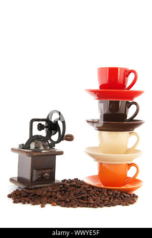 Stacked cups and saucers with coffee beans isolated over white background Stock Photo