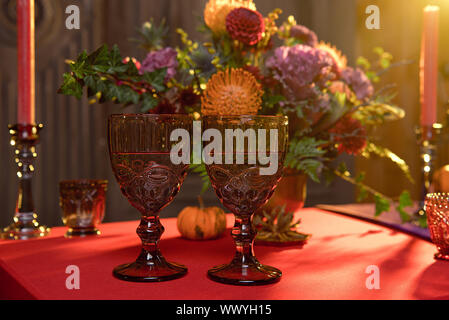 Halloween table festively decorated composition of flowers candles candles pumpkin glasses with wine Stock Photo