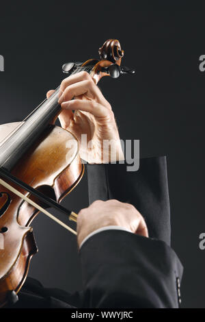 the violinist: Musician playing violin on dark background Stock Photo