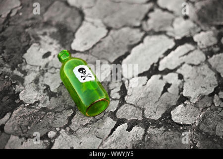 Bottle with the poison lying on poisoned ground Stock Photo
