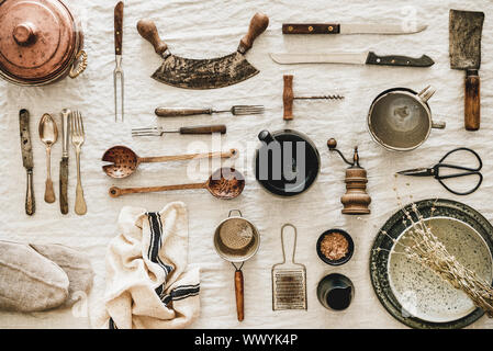 Kitchen utensils and tablewear over linen tablecloth, top view Stock Photo
