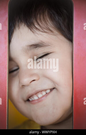 Happy child, Brunette boy putting funny faces in an outdoor park Stock Photo