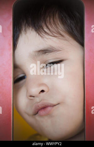 Brunette boy putting funny faces in an outdoor park Stock Photo