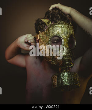 Atomic Man with gold gas mask and arabesques in poses of drowning and desperation, depression and psychiatry concept. Stock Photo
