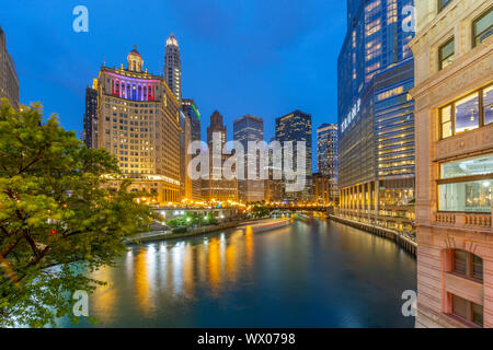 View of Chicago River and buildings illuminated at dusk, Chicago, Illinois, United States of America, North America Stock Photo