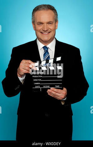 Its showtime. Businessman holding clapperboard Stock Photo