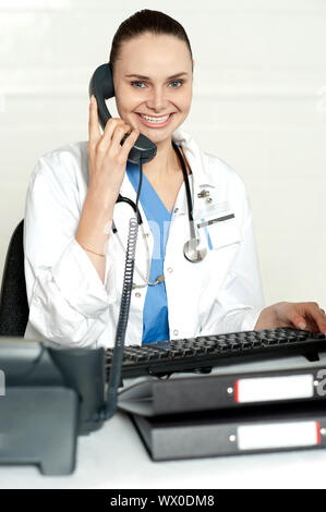 Medical expert communicating on phone and smiling at camera Stock Photo