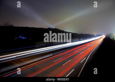 light streaks on highway A2 and the light beams on stockpile Rungenberg, Gelsenkirchen, Germany Stock Photo