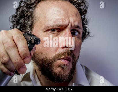 cleaning spray, man with intense expression, white shirt Stock Photo
