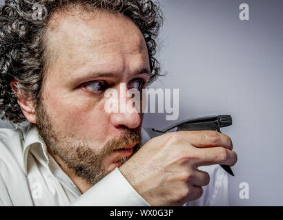 cleaning spray, man with intense expression, white shirt Stock Photo