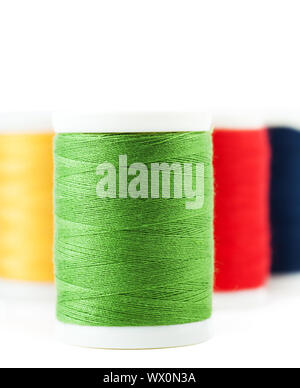 Four thread spools over white background Stock Photo
