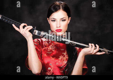 Pretty woman holding katana weapon Stock Photo