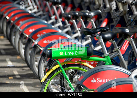 London, England, UK. Row of rental bikes - one electric Lime-E cycle among Santander hire cycles Stock Photo