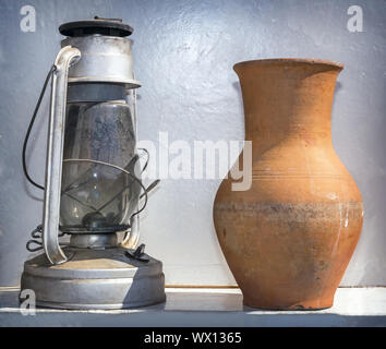 Antique objects of everyday life: a kerosene lamp and a pitcher. Stock Photo