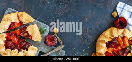Summer pies with red and yellow plums on the serving board. Stock Photo
