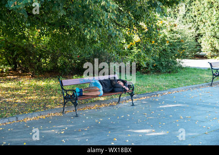 Homeless sleeping on a bench, Warsaw, Poland Stock Photo