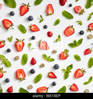 Appetizing berries with green petals of mint on a gray background. Food layout. Flat lay Stock Photo