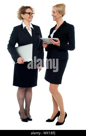 Full length portrait of two businesswomen discussing business isolated over white Stock Photo