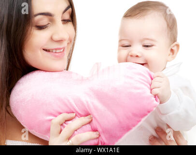 happy baby and mama with heart-shaped pillow Stock Photo
